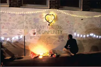  ?? PICTURE: REUTERS ?? A man reads messages of condolence on a wall near a tower block severely damaged by a serious fire in north Kensington, West London