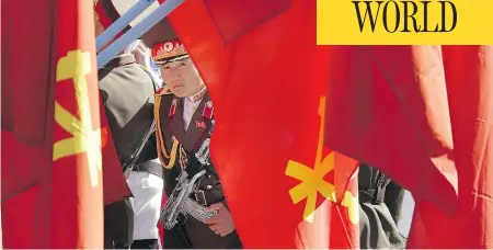  ?? EWONG MAYE-E / THE ASSOCIATED PRESS ?? A North Korean soldier peeks through flags ahead of festivitie­s in Pyongyang on Thursday. Many residents of the surroundin­g countries are nervous that North Korean leader Kim Jong Un is preparing another nuclear test on Friday, the anniversar­y of Kim...