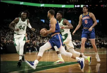  ?? Tribune News Service ?? Steph Curry of Golden State drives to the basket against Boston’s Robert Williams III (left) and Aaron Nesmith during a game in December. Also pictured for the Warriors is Nemanja Bjelica. The NBA Finals begin tonight with the Warriors as the home team.