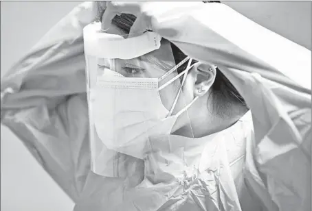  ?? STACEY WESCOTT/CHICAGO TRIBUNE ?? Monica Gomez, a staff nurse at Amita Health St. Alexius Medical Center Hoffman Estates, exits a patient’s room Thursday.