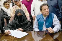  ?? AFP FILE PHOTO ?? FOR RICHER OR POORER
Pakistan’s former prime minister Imran Khan (right) sits beside his wife Bushra Bibi as she signs surety bonds for bail at a court registrar’s office in the eastern city of Lahore on July 17, 2023.