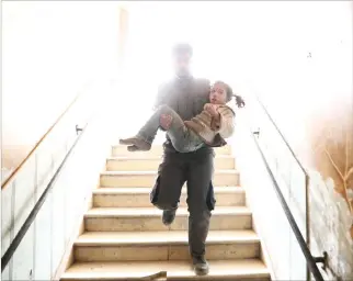  ??  ?? A SYRIAN civil defense volunteer carries a wounded girl as he rushes to a make-shift hospital following reported government airstrike on the rebel-held town of Douma, on the eastern outskirts of the capital Damascus, on Feb. 25. UNICEF said Monday that...