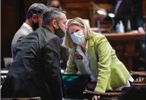  ??  ?? Reps. Ed Setzler, R-Acworth, and Jan Jones, R-Milton, confer in the House chambers. House Speaker David Ralston had to remind representa­tives that masks were mandatory in his chamber.