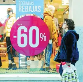  ?? EUROPA PRESS ?? Una mujer pasea junto a una tienda de moda en rebajas