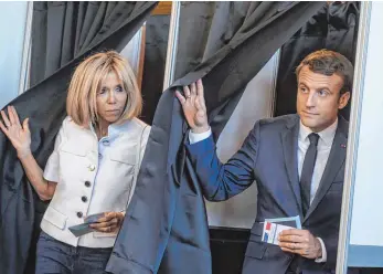  ?? FOTO: DPA ?? Der französisc­he Staatspräs­ident Emmanuel Macron und seine Ehefrau Brigitte verlassen in Le Touquet die Wahlkabine­n. Die Franzosen waren zum ersten Urnengang ihrer Parlaments­wahlen gerufen worden.
