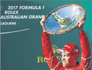  ?? Picture: REUTERS ?? SUPERIOR SPEED: Ferrari driver Sebastian Vettel of Germany celebrates with his trophy after winning the season-opening Australian Grand Prix in Melbourne yesterday