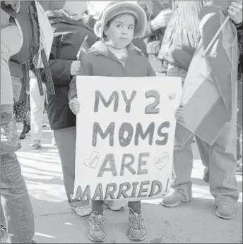  ?? | CAROLYN KASTER~AP ?? Gabriela Fore, 6, of Upper Darby, Pa., holds a sign with her moms outside the Supreme Court on Wednesday.