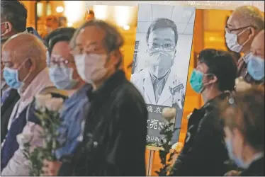  ?? (File Photo/AP/Kin Cheung) ?? People wearing masks attend a vigil for Chinese doctor Li Wenliang in February 2020 in Hong Kong. The outpouring of grief and rage sparked by Li’s death was an unusual — and for the Chinese Communist Party, unsettling — display in China’s tightly monitored civic space.