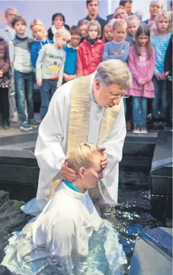  ??  ?? „Ich konnte am ganzen Körper spüren, dass etwas Neues beginnt“– Tina Stadtfeld bei ihrer Ganzkörper­taufe in der katholisch­en Kirche St. Maria Magdalena mit Pastor Dietmar Schmidt.