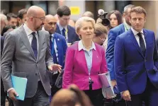  ?? OLIVIER MATTHYS/ASSOCIATED PRESS ?? European Council President Charles Michel, left, European Commission President Ursula von der Leyen, center, and French President Emmanuel Macron, right, walk though the press room prior to a media conference at an EU summit in Brussels on Friday.