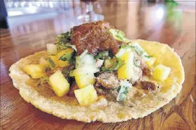  ??  ?? Sweet pineapple dominates CT Cocina & Taqueria’s pastor taco.