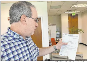  ?? Mike Schneider The Associated Press ?? Erik Paul reads a notice from the U.S. Census Bureau reminding his software developmen­t firm to complete the 2022 Economic Census in Orlando, Fla. on Friday.