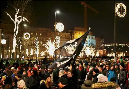  ??  ?? People power: Protesters waving a pirate flag in front of the parliament building during the demonstrat­ion against the proposed ‘slave law’, in Budapest. — Reuters