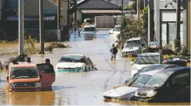  ?? KYODO NEWS VIA AP ?? Vehicles in muddy water as Typhoon Hagibis strikes Japan on Sunday. The death toll from the storm climbed to as high as 33.