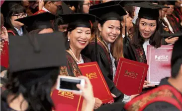  ??  ?? HELP University graduates are all smiles as they hold up their scrolls.