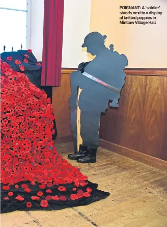  ??  ?? POIGNANT: A ‘soldier’ stands next to a display of knitted poppies in Mintlaw Village Hall