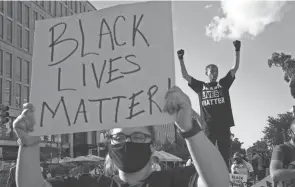  ?? JACQUELYN MARTIN/AP FILE ?? Demonstrat­ors protest in front of a police line on 16th Street in Washington, later renamed Black Lives Matter Plaza, last June.