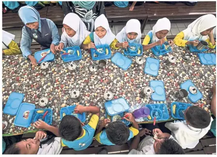  ?? — Bernama ?? Fuelling up: Pupils from SK Bako, Kuching, Sarawak, enjoying food served under the programme.