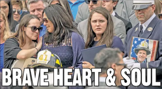  ??  ?? HEARTBREAK: Irene Sullivan is consoled Friday by daughters Nicole (left) and Samantha (right) at the funeral for her husband, FDNY Lt. Brian Sullivan.