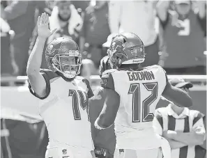  ?? KIM KLEMENT/USA TODAY SPORTS ?? Ryan Fitzpatric­k high-fives wide receiver Chris Godwin after a TD Sunday. The Bucs quarterbac­k now has eight TD passes.