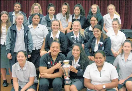  ?? WP220518BR­01 ?? Black Ferns prop Toka Natua (centre) with the Te Awamutu College Girls 1st XV and the trophy earned in New Zealand’s win in the 2017 Women’s Rugby World Cup final.