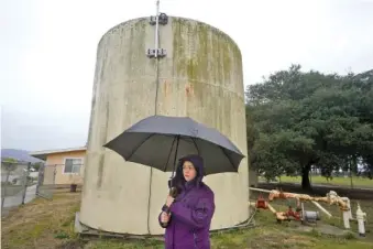  ?? AP PHOTO/JEFF CHIU ?? On Dec. 20, Ileana Miranda is interviewe­d in front of an old San Jerardo cooperativ­e water tank in Salinas, Calif.