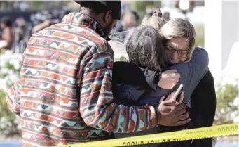 ?? MARCIO JOSE SANCHEZ/AP ?? Mourners embrace Thursday in Thousand Oaks, Calif., after a gunman shot and killed 12 people late Wednesday at a bar that was holding a country music dance night for college students.