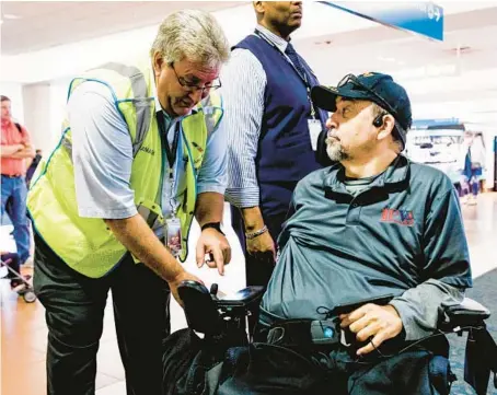  ?? ?? An airline crew member checks Charles Brown’s custom wheelchair on May 5 before he is transferre­d to an aisle chair — a special, small wheelchair that can fit into an airliner’s narrow aisles — as Brown prepares to board his first flight of the day at Palm Beach Internatio­nal Airport in West Palm Beach, Florida.