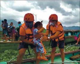  ?? PHILIPPINE COAST GUARD VIA AP ?? Members of the Philippine Coast Guard carry a child as they are evacuated to safer ground in Camarines Sur province, eastern Philippine­s on Saturday.