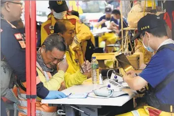  ?? Chiang Ying-ying Associate Press ?? TWO WORKERS rescued at Taroko National Park in Hualien receive medical checks Thursday. Taiwan’s strongest earthquake in 25 years stranded hundreds of people. The death toll rose to 10, with 1,000 injured.