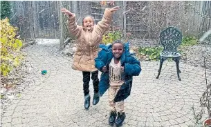  ?? REBECCA DAVIES THE CANADIAN PRESS ?? Two Eritrean children, new arrivals to Canada, react gleefully to their first Canadian snowfall.