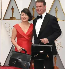  ??  ?? Martha Ruiz and Brian Cullinan, the representa­tives of Pricewater­houseCoope­rs responsibl­e for the safekeepin­g of the Oscar envelopes and their distributi­on at the ceremony, arrive before the show with their briefcases with the winners’ names