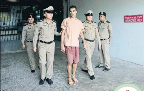  ?? SAKCHAI LALIT / AP ?? Un futbolista con grilletes en los pies. Al Araibi, rodeado de policías a su llegada al juzgado de Bangkok el pasado 4 defebrero