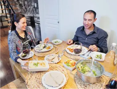  ??  ?? Alli Carr and Michael Engels sit down to a Mediterran­ean vegan meal they prepared together: homemade hummus, roasted eggplant with bulgur, herbs and vegan sour cream, chopped salad with a tahini dressing and lima beans in tomato and garlic.