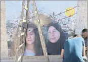  ?? NASSER NASSER — THE ASSOCIATED PRESS ?? Palestinia­ns hang a poster showing Nariman Tamimi, right, and her daughter, Ahed, during preparatio­ns for their upcoming release from an Israeli prison.