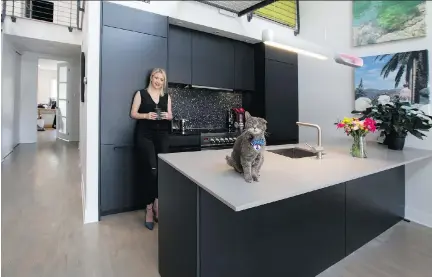  ?? CHRISTINNE MUSCHI ?? Keren Blankrot chose black as her primary design feature. It started with smooth and sleek Leicht kitchen cabinets and a backdrop with black ceramic tiles that have angular and uneven edges. Farmer the cat makes himself comfortabl­e on the kitchen...