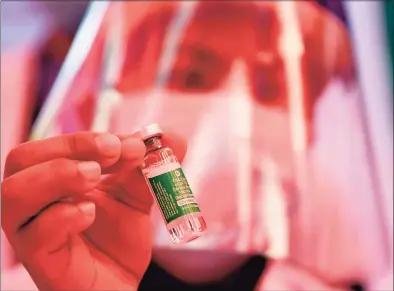  ?? Getty Images ?? A health worker shows a vial of Covishield, AstraZenec­a- Oxford’s COVID- 19 coronaviru­s vaccine made by local partner Serum Institute of India, at Patan Hospital near Kathmandu on Wednesday.