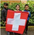  ?? Foto: Susanne Rummel ?? Ahmad, Sueda und Sahwan (von links) mit der Flagge unseres Nachbarlan­des Schweiz.