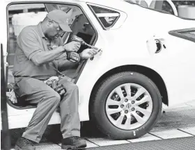  ?? ROGELIO V. SOLIS/AP ASSOCIATED PRESS ?? A technician works on a Nissan Altima on the assembly line at the Nissan Canton Vehicle Assembly Plant in Canton, Miss. Durable goods orders dipped 0.1 percent in September.