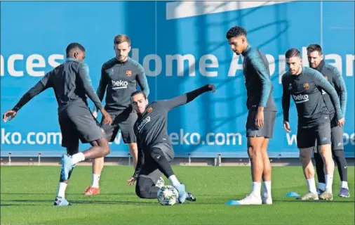  ??  ?? Griezmann pelea por una pelota durante el entrenamie­nto del equipo por la mañana en Barcelona antes de viajar a Milán.