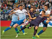  ?? — AP ?? Barcelona’s Luis Suarez (centre) vies for the ball with Malaga’s Ignacio Camacho (left) and Luis Hernandez.