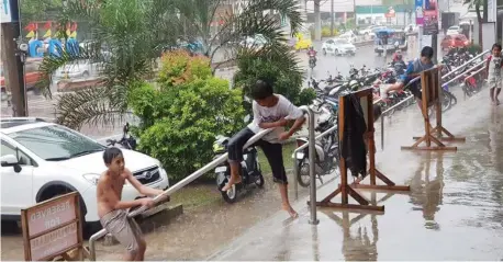  ?? (NEF LUCZON) ?? THESE children in CM Recto Ave were unmindful of the heavy downpour yesterday and seemed to enjoy the rain instead.