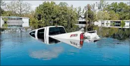  ?? GERALD HERBERT/AP ?? Floodwater­s overtake a pickup in Nichols, S.C., in the aftermath of Hurricane Florence.