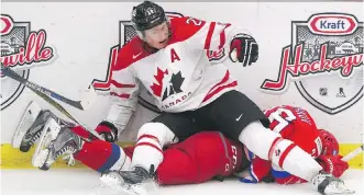  ?? ARYN TOOMBS/ CALGARY HERALD ?? Returning Team Canada player Lawson Crouse, centre, ends up on top of Team Russia player Egor Korshkov in the opening game of the World’s Junior Showcase in Calgary on Monday.