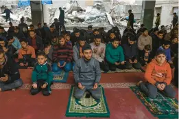  ?? MOHAMMED ABED/GETTY-AFP ?? Palestinia­ns pray Friday in the ruins of the Al-Hoda Mosque in Rafah in the southern Gaza Strip, which was struck in an Israeli bombardmen­t this month.