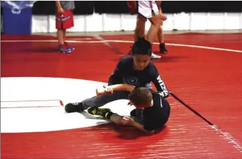  ?? PHOTO AARON BODUS ?? A young grappler succeeds in taking down his training partner at the Heart and Hustle wrestling clinic on Thursday.