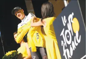  ?? Peter Dejong / Associated Press ?? Britain’s Chris Froome gets help in putting on the overall leader’s yellow jersey.