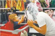  ?? Brynn Anderson, The ?? Liam Vasquez, 2, and his father, Will Vasquez, try on Halloween masks at a Target department store on Wednesday in Pembroke Pines, Fla.