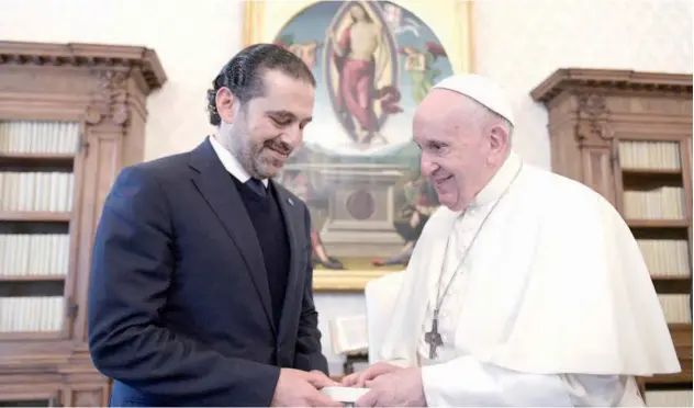  ?? Agence France-presse ?? ↑
Pope Francis and Saad Hariri exchange gifts during a private audience in The Vatican on Thursday.