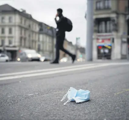  ??  ?? A discarded protective face mask lies on a sidewalk amid the COVID-19 outbreak, in Lausanne, Switzerlan­d, May 14, 2020.